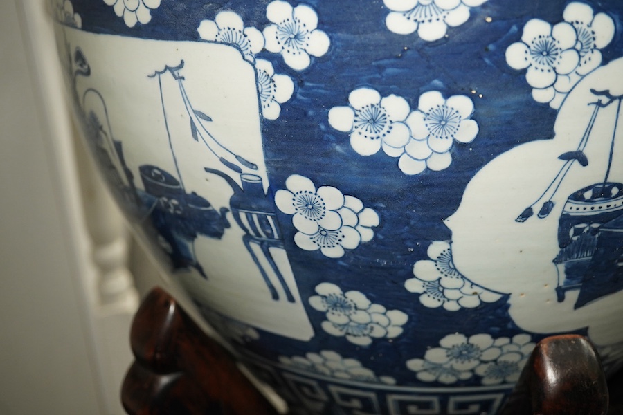 A large Chinese blue and white ‘Hundred Antiques’ jardinere and hongmu stand, late 19th/early 20th century